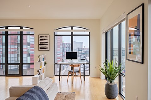 a living area with a couch and a desk with a computer
